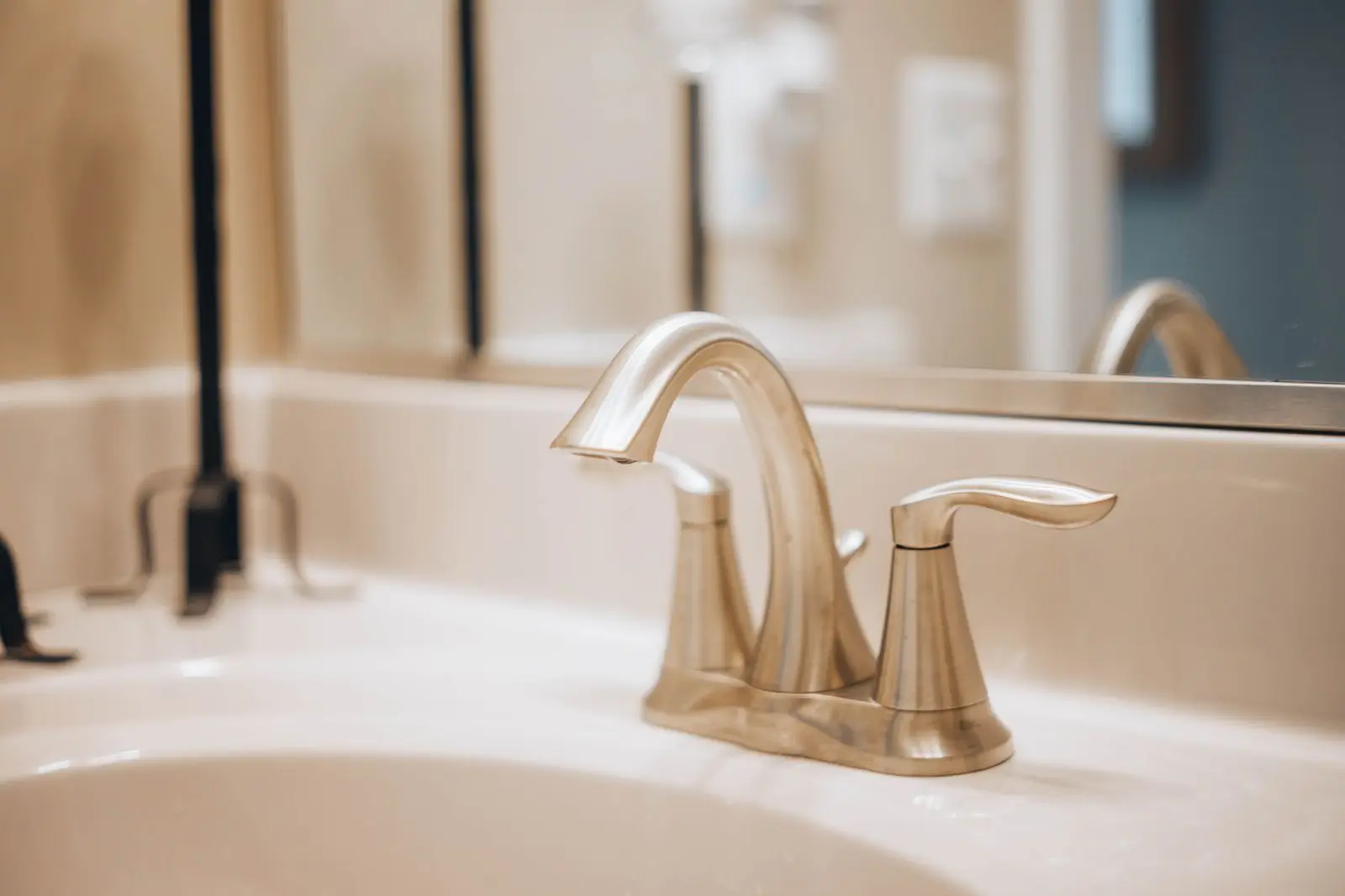 Brushed nickel bathroom faucet on a white sink